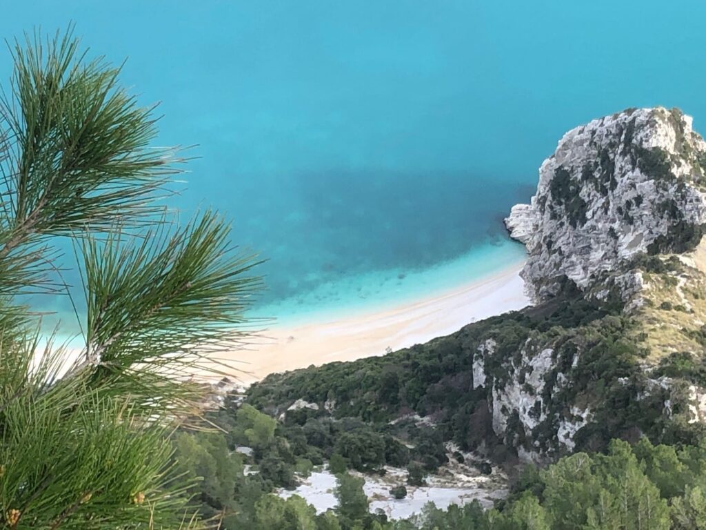 Turquoise waters on a beach seen from a cliff