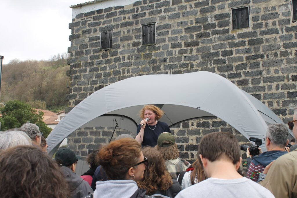 Woman singing in a tent with onlookers