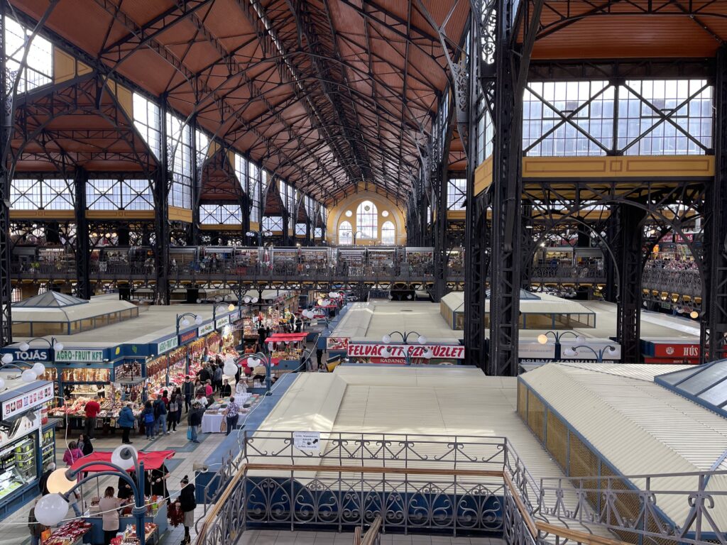 Inside of a vast market hall with food stalls