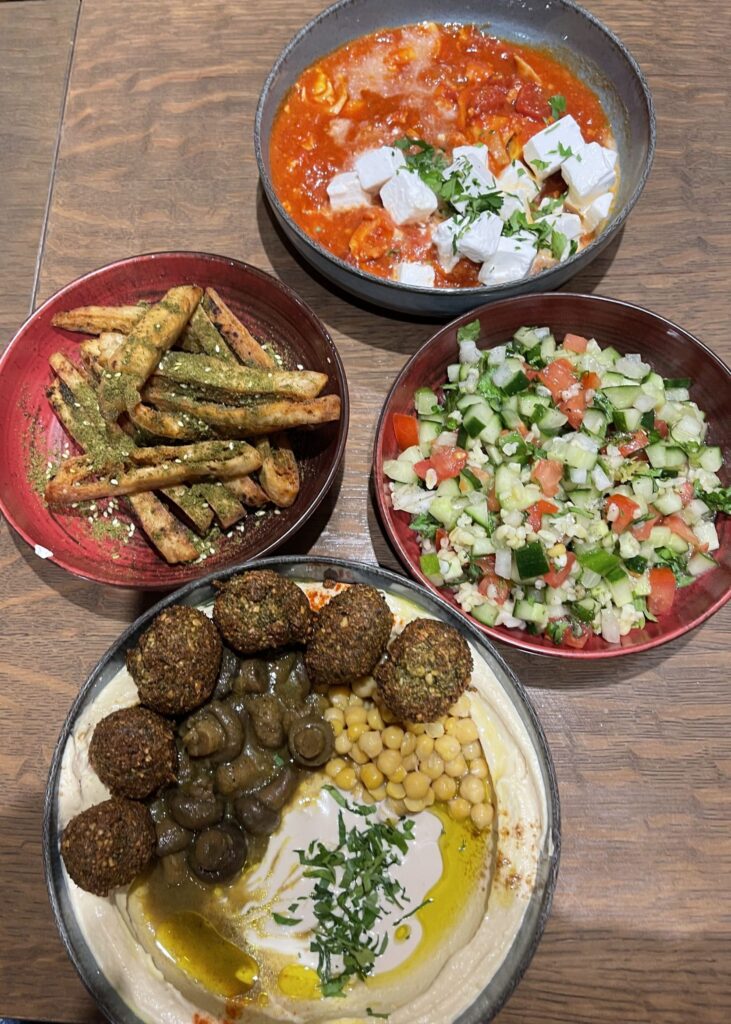 Table with four dishes of mezze food