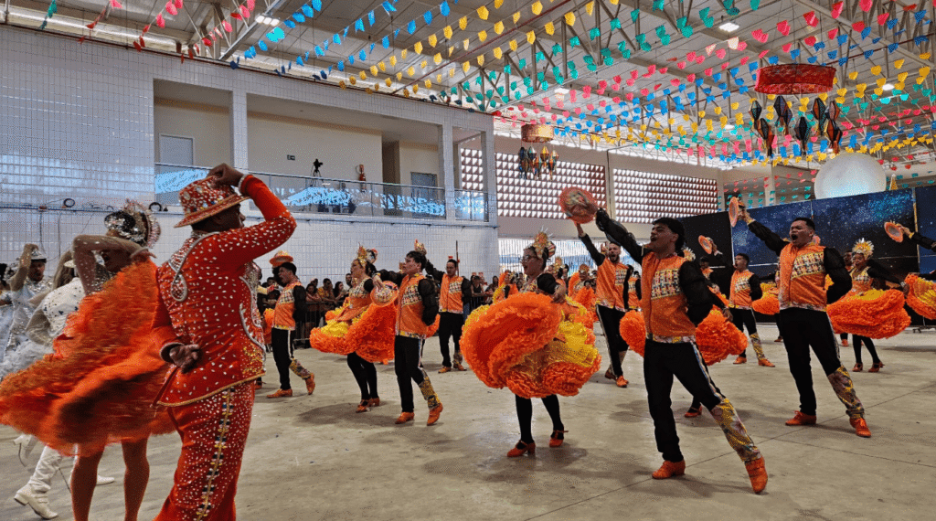 Dancers clad in orange outfits performing group routine