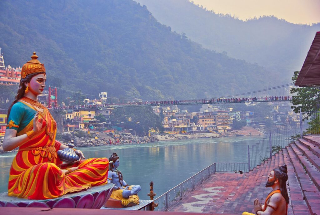 Statue of woman in yoga pose by a river in a city