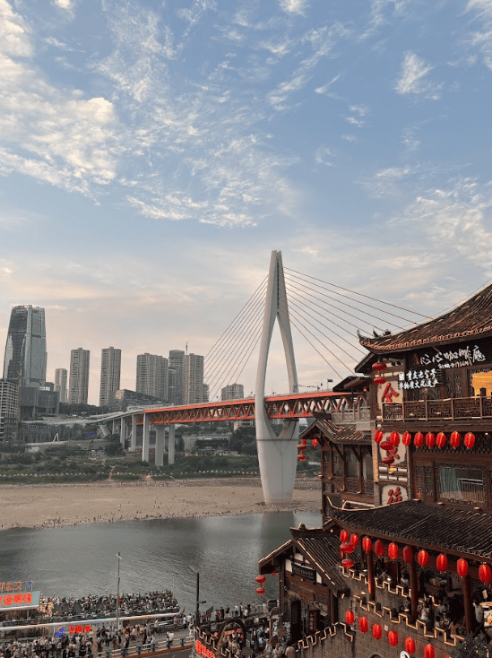 Bridge spanning a big river linking skyscrapers on one side and old buildings on the other.