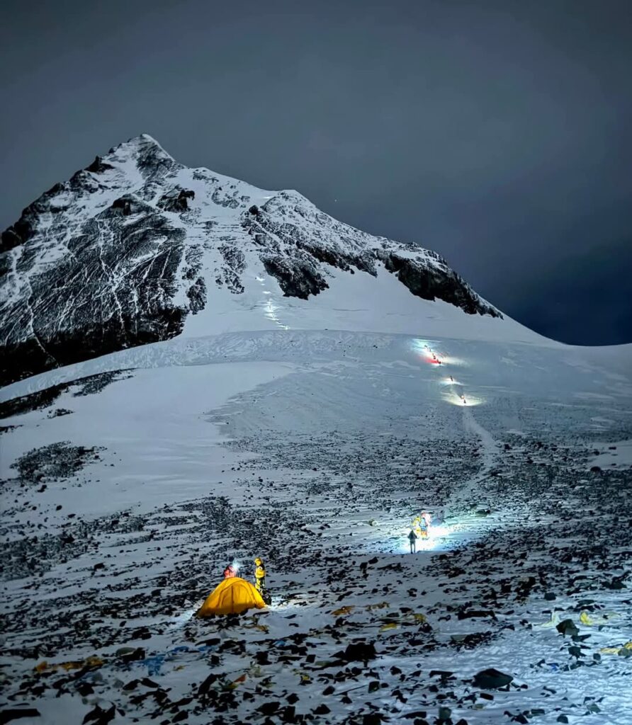 Lit trail of climbers heading up a snow covered mountain
