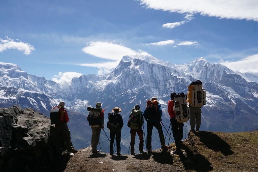 Group of mountaineers looking at snow capped mountain range