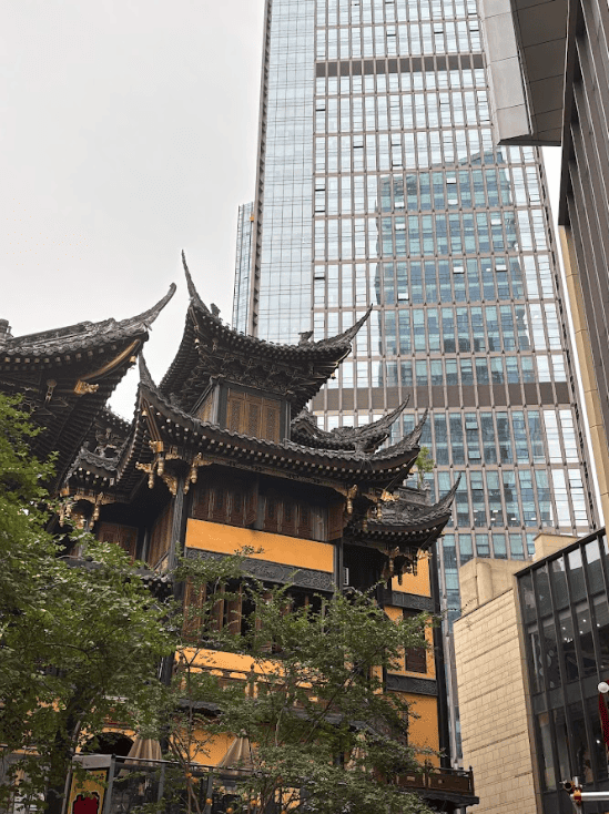 Old style building with pointed roof among skyscrapers