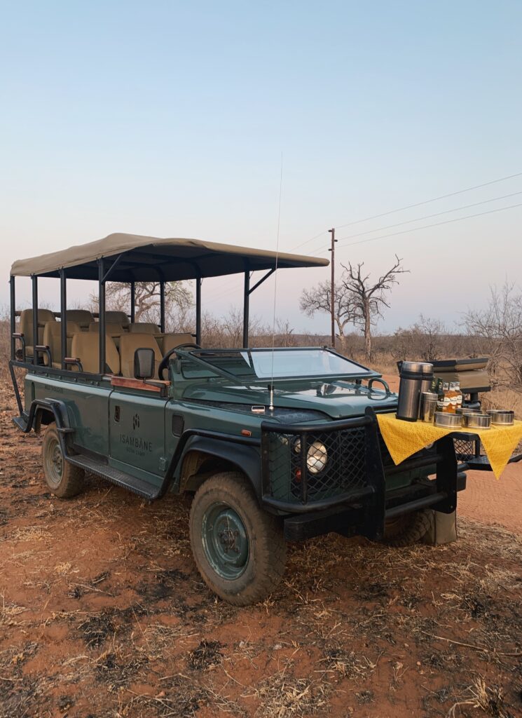 Safari vehicle in the bush, decked out with drinks and snacks