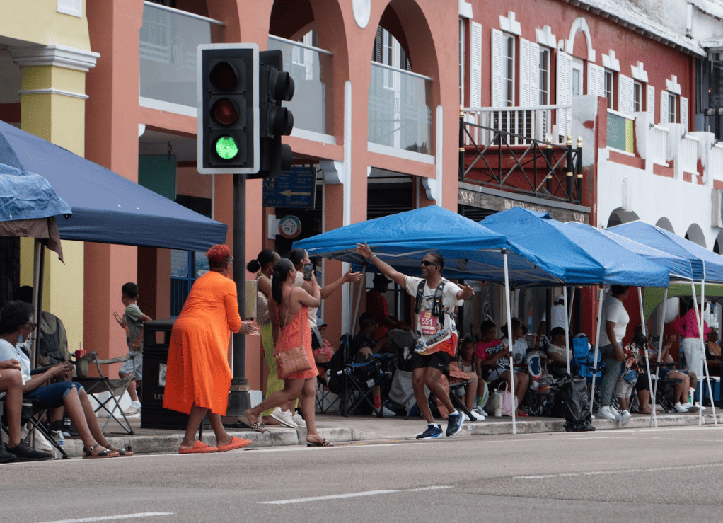 People on side of street greeting marathon runner