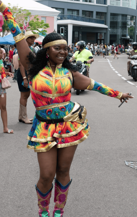Woman dressed in colourful outfit posing at a parade