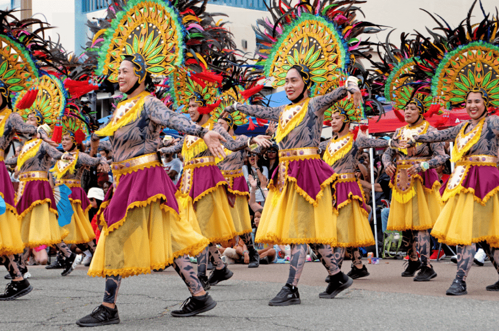 Performers in colourful dresses and head ornaments.