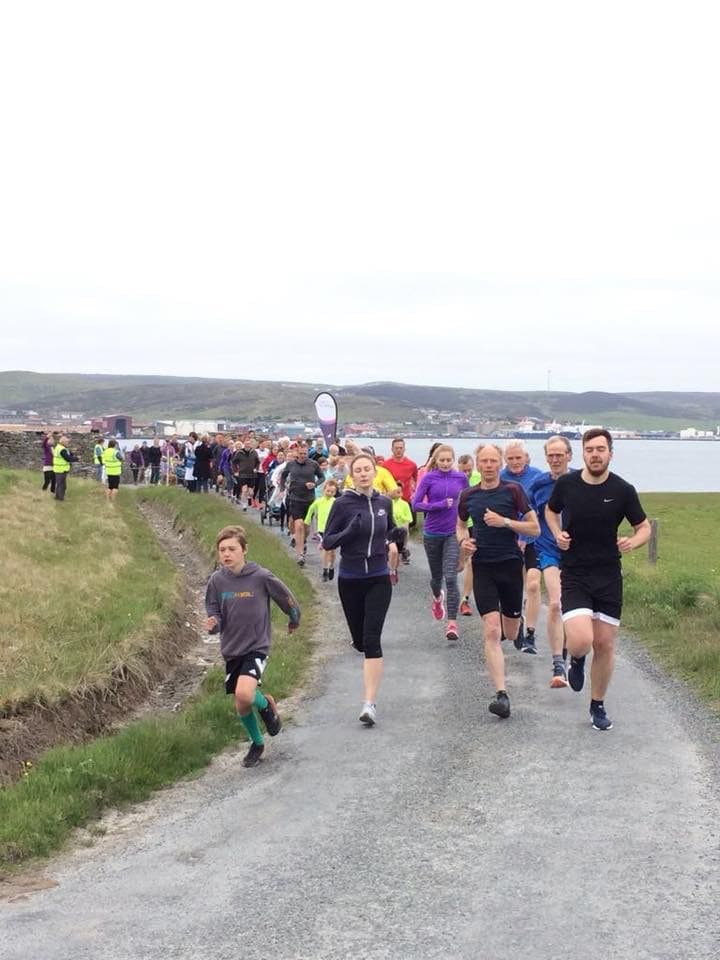 People in foot race on a gravel road by the water