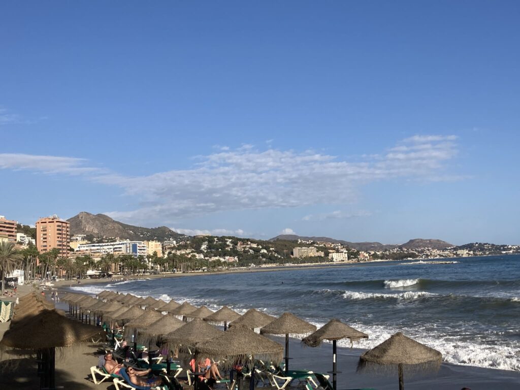 Beach with sun chair and city seen from the bay