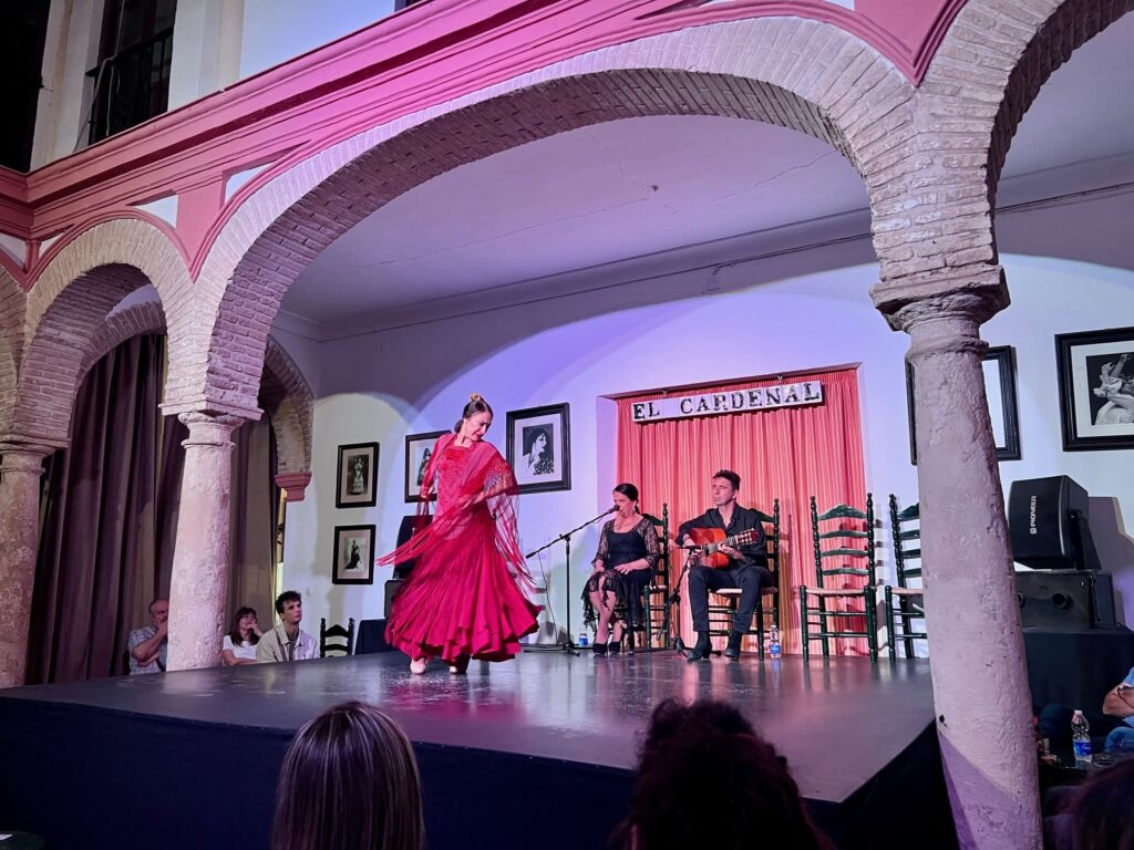 Woman in red dress dancing on stage with guitar player in background