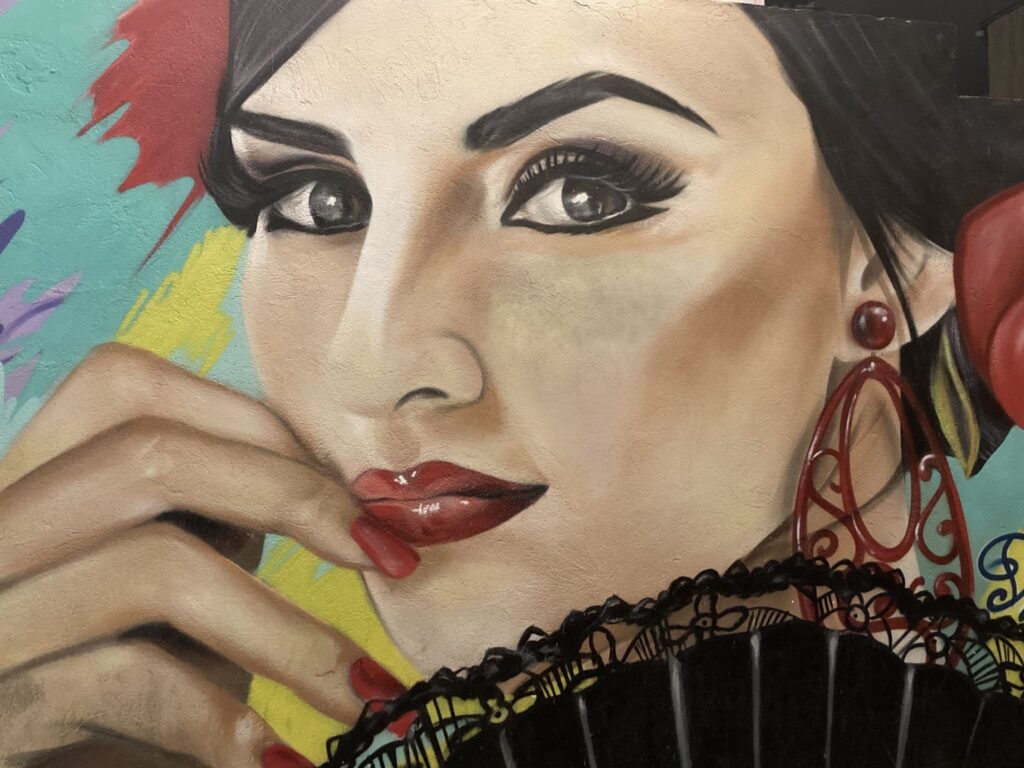 Face of a woman with red lipstick and black mascara on a mural