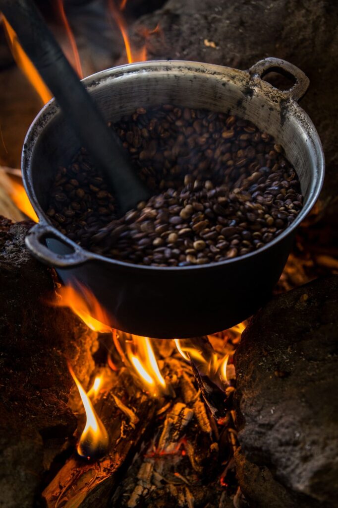 Coffee beans roasting in pot over open fire