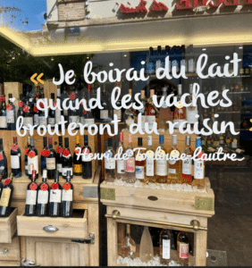 Quote in French on store front window displaying wine