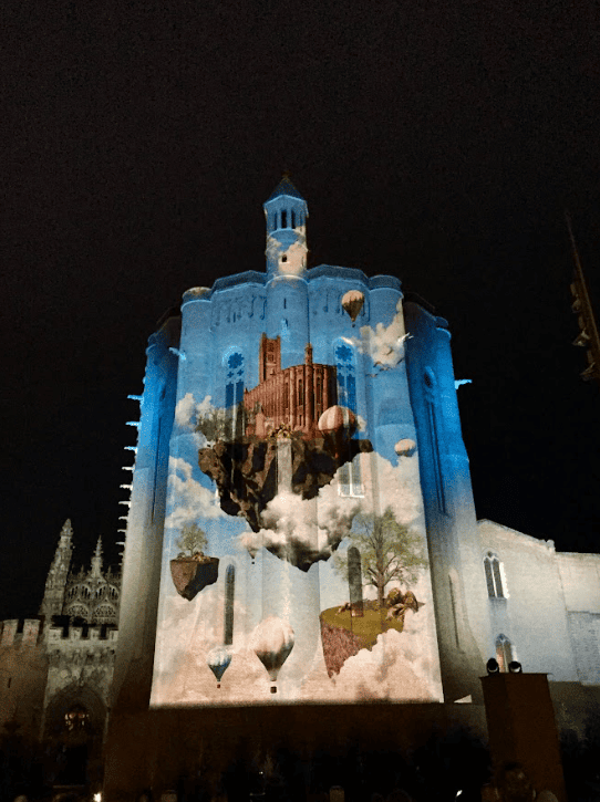 Sound and light projection onto church facade at night.