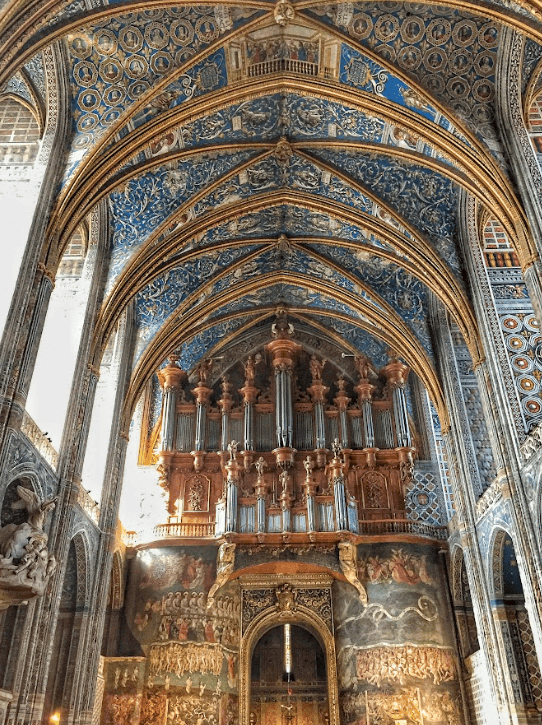 Large organ inside cathedral with blur ornate ceiling