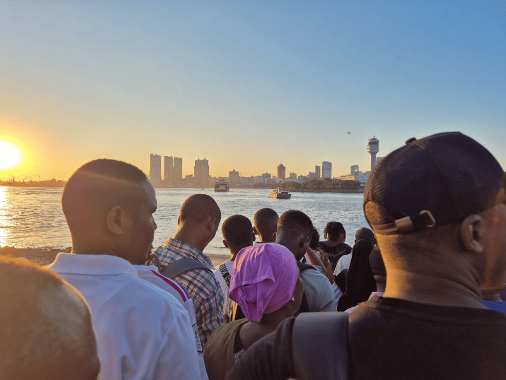 Group of people on a ferry with cityscape in background