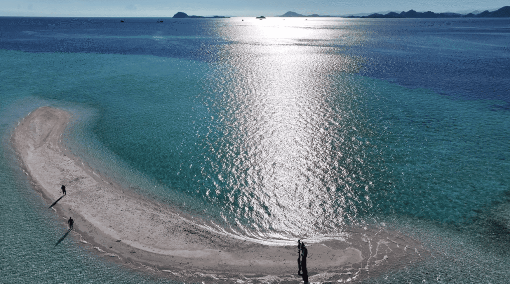 A sandy islet with a few people on it