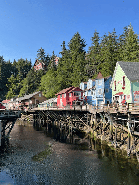 Colourful houses on stilts near a forest and lake