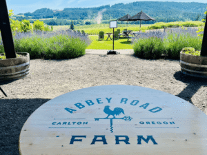 Table overlooking vineyard with text: Abbey Road Farm