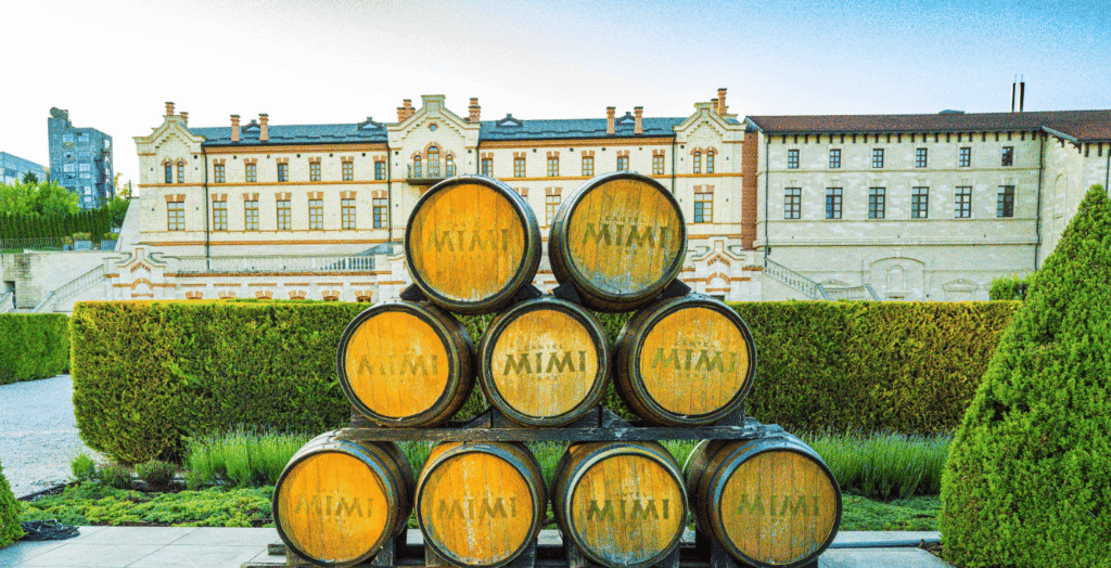 Stacked wine barrels in front of a large castle