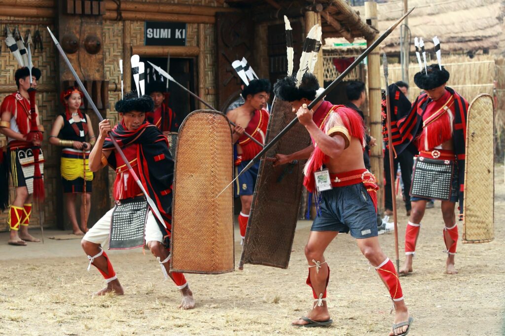 Men in traditional dress fighting with spears and shields