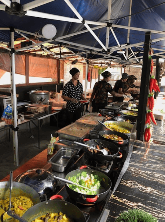 Covered food market with stoves and food in pans