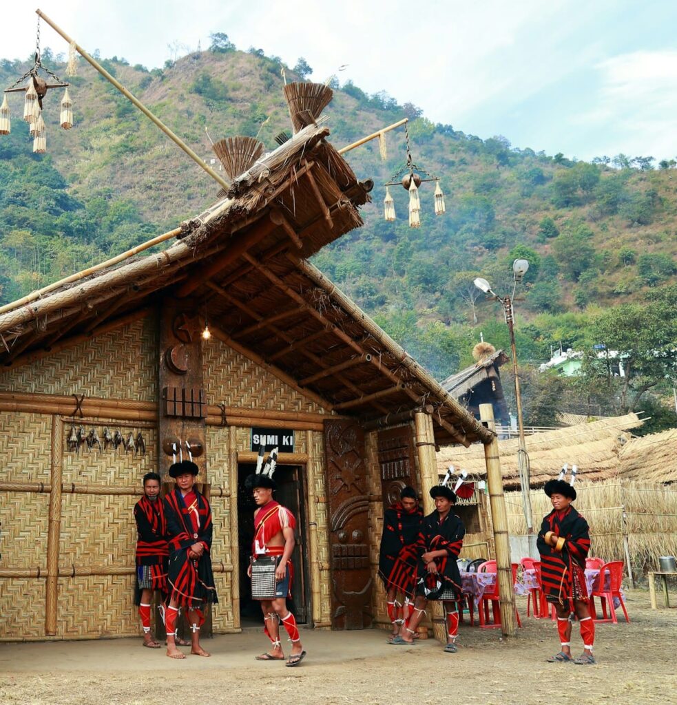 Hut with people in decorative outfits near the entrance