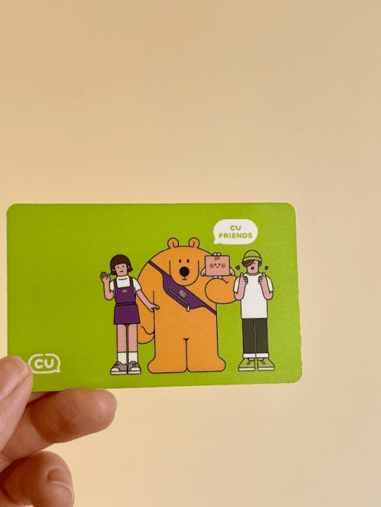 Human hand is holding a green card with a drawing on top of it.